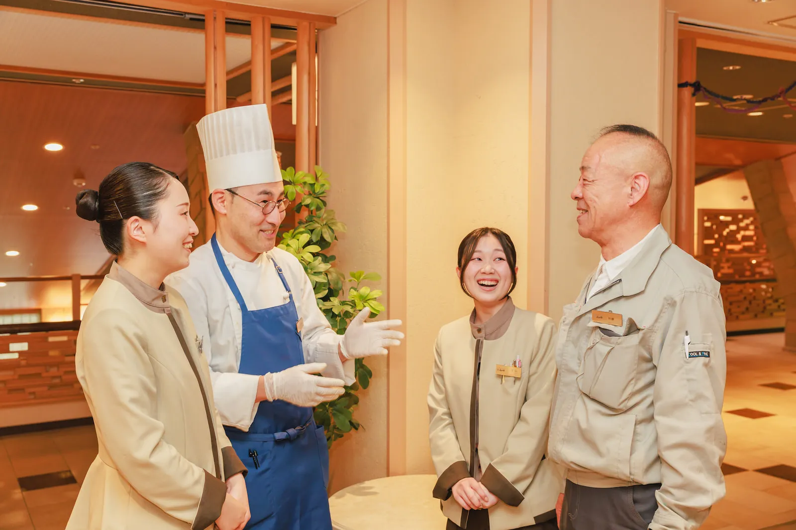 接客スタッフ・料理人・施設管理スタッフが笑顔で交流する様子